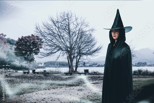 woman in Black Scary witch halloween costume with moonlight in a dark forest