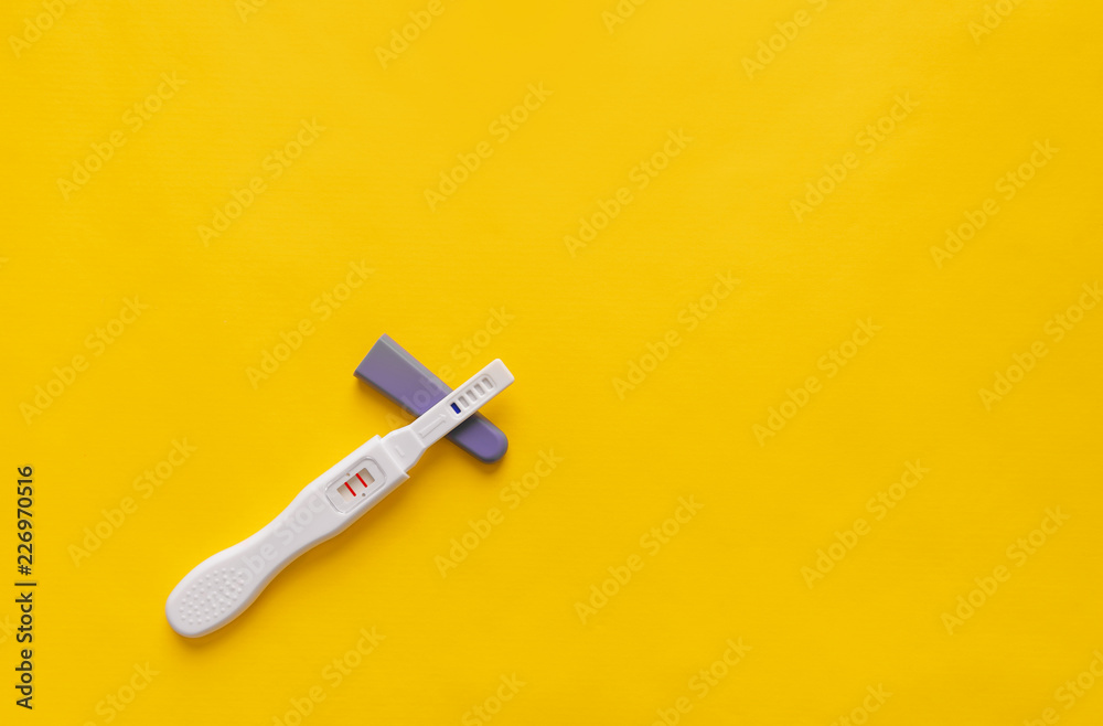 Pregnancy test on a yellow background. Close-up. Pregnancy test on a yellow background. Close-up.