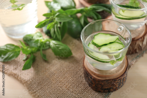 Glass cup of tasty cucumber water on table