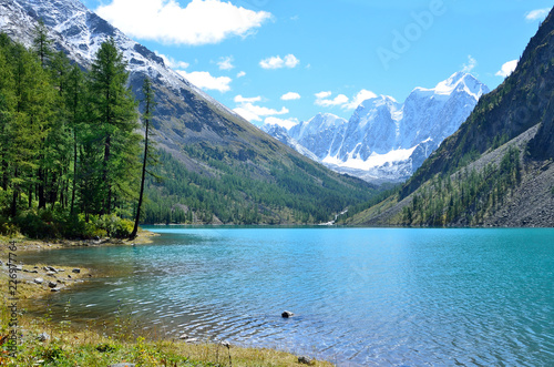  Large Shavlinskoye lake in sunny day in the background of the mountains Skazka and Krasavitsa (Tale and Beautiful) in a, Altai mountains, Russia