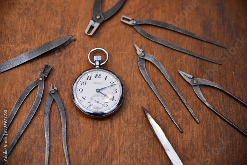 pocket watch and tools on a table in Trifle photo