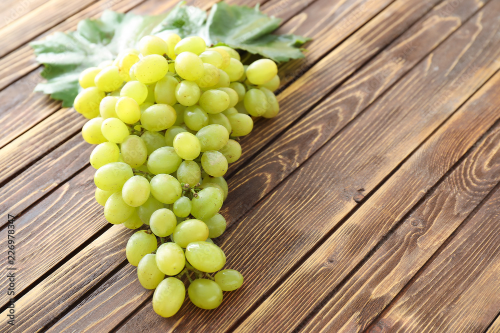 Ripe juicy grapes on wooden table Ripe juicy grapes on wooden table