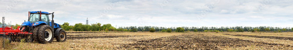 Tractor with disc harrow working in the field Tractor with disc harrow working in the field