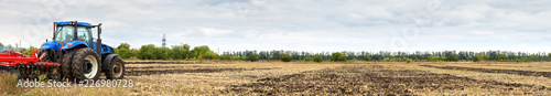 Tractor with disc harrow working in the field