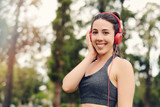 Young beautiful woman with red headphones listening music