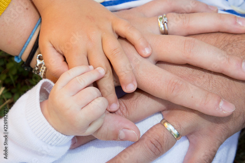 Four hands of cheerful family baby son child mother and father
