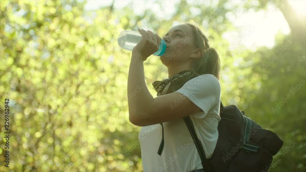 Young beautiful woman drinking water on hiking Young beautiful woman drinking water on hiking
