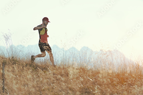 Photos Man runs downhill among the autumn mountain meadows