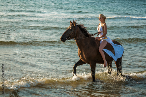beautiful young woman in white dress by the sea with horse © Екатерина Переславце