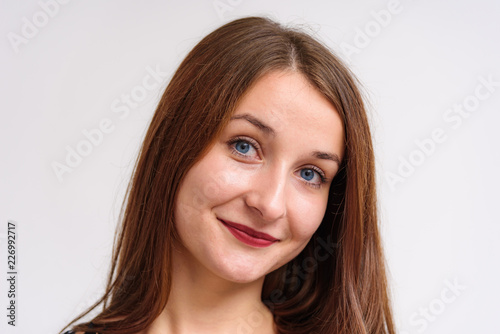 Studio portrait of a beautiful brunette girl on a white background with different emotions.