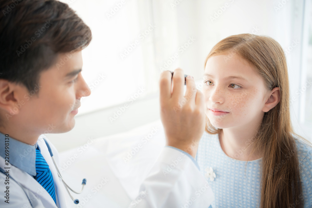 Friendly smart doctor checking girl's eye in hospital. Friendly smart doctor checking girl's eye in hospital.
