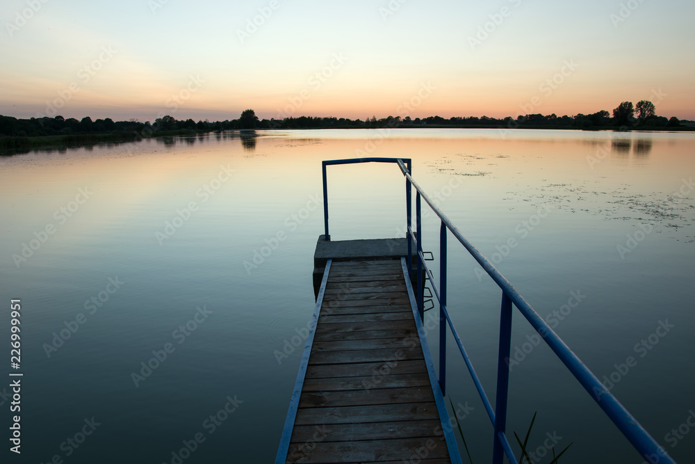 Bridge on the lake and cloudless sky after sunset. Staw, Poland