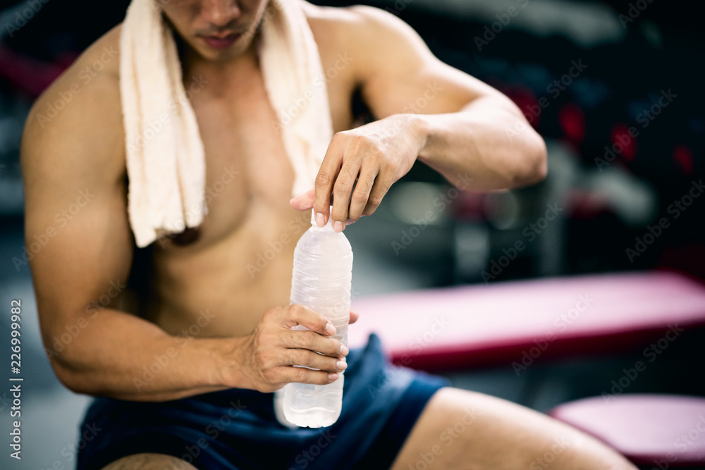 Φωτογραφία Portrait of Fresh Asian man opening a bottle of water after exercise at gym on break