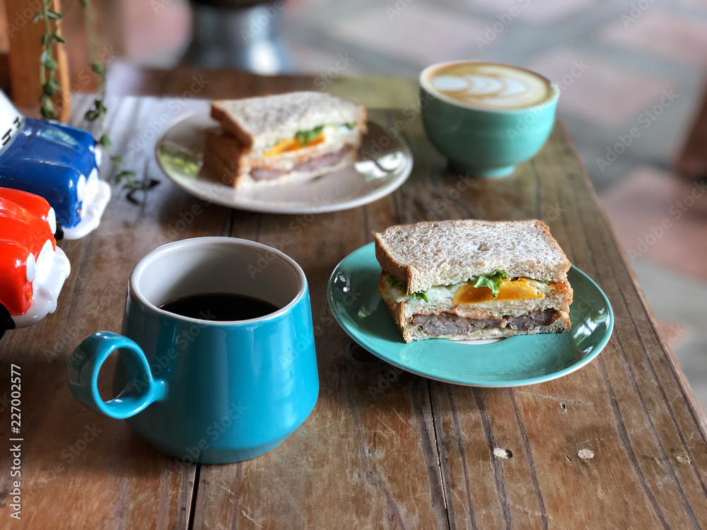 Healthy Breakfast with special one, Homemade fresh sandwich and coffee cup on green plate set. Black coffee and Latte art coffee.