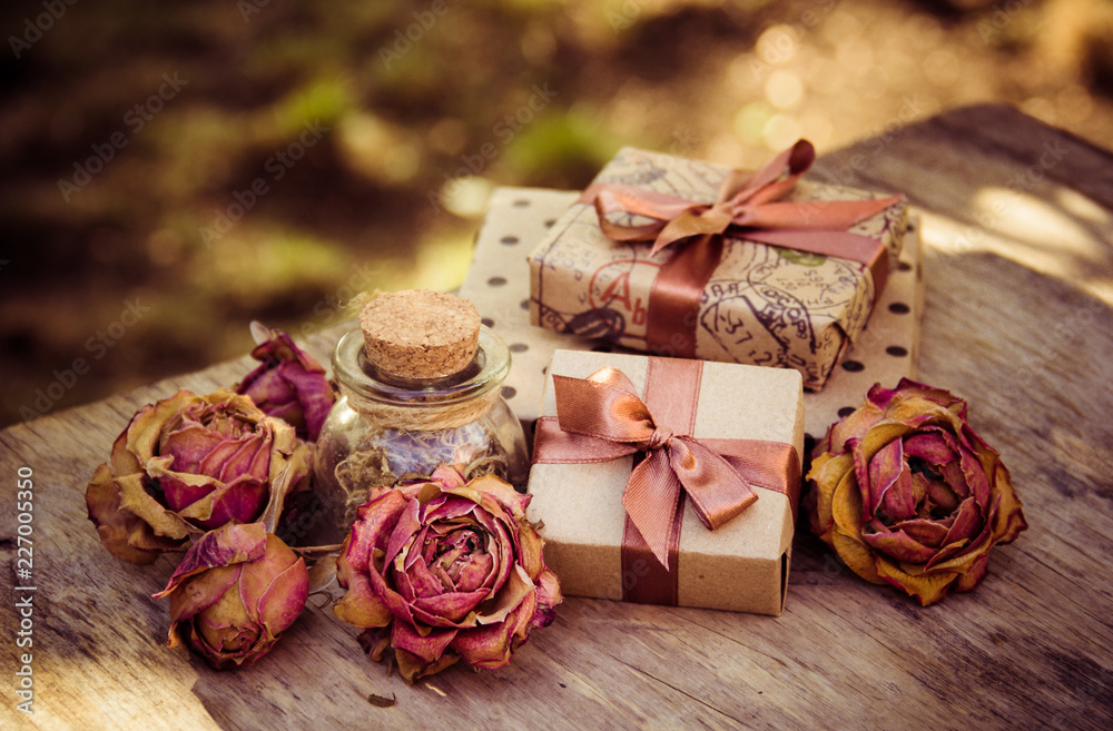 Gift boxes and dry roses. Dried flowers and craft gift box. Romantic concept. Gifts in brown paper Gift boxes and dry roses. Dried flowers and craft gift box. Romantic concept. Gifts in brown paper