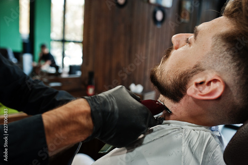 Handsome bearded man at the barbershop, barber at work.