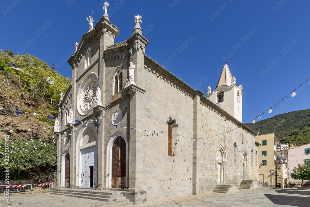 The beautiful Church of St. John the Baptist against the blue sky, Riomaggiore, Cinque Terre, Liguria, Italy
