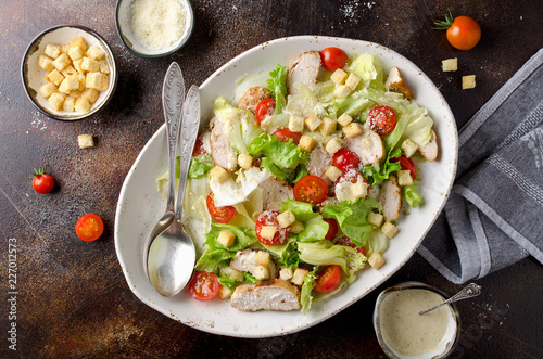 Caesar salad with chicken, tomatoes, Parmesan and croutons