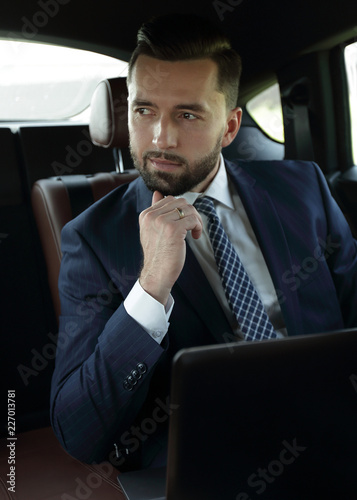 businessman with laptop sitting in a comfortable car © ASDF