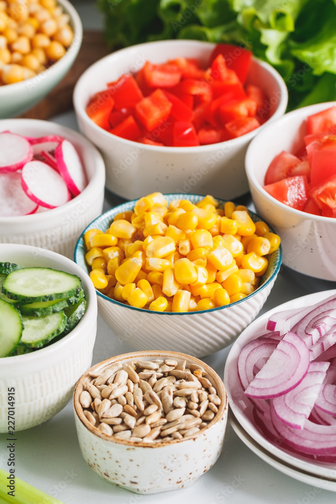Various ingredients for healthy vegetarian salad in different portion bowls on a table. The concept of fitness and vegan food. Various ingredients for healthy vegetarian salad in different portion bowls on a table. The concept of fitness and vegan food.