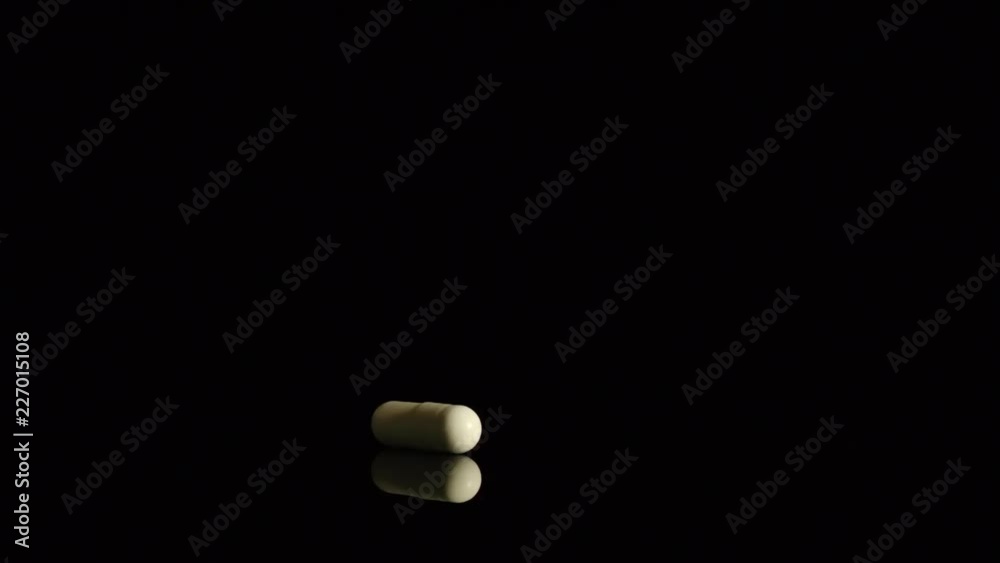 SLOW MOTION: One capsule falls in the darkness SLOW MOTION: One capsule falls in the darkness