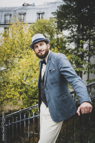 Homme style retro posant dans les escaliers et devant les immeubles parisiens, Montmartre, France photo