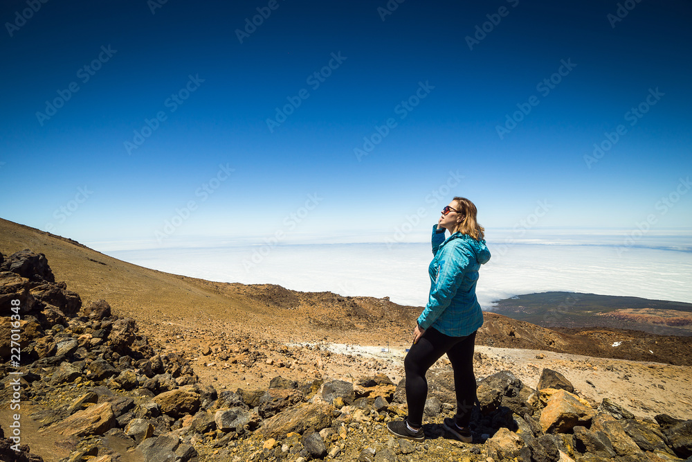 girl over the clouds on top of the mountain by the volcano Teide, Tenerife, Canary Island, Spain girl over the clouds on top of the mountain by the volcano Teide, Tenerife, Canary Island, Spain