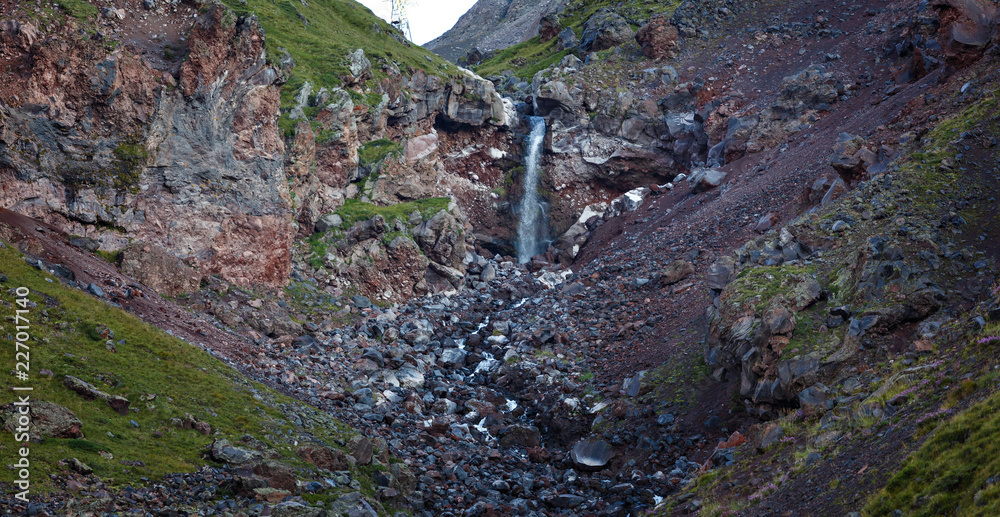 Fototapeta premium Waterfall on the rocky slopes of the Caucasus Mountains in Russia.