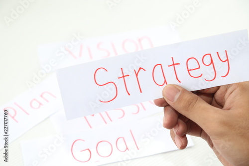 business hand writing a piece of strategy paper