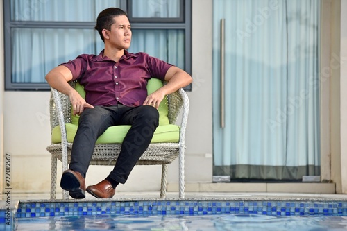 Serious Male Person Sitting By Pool photo