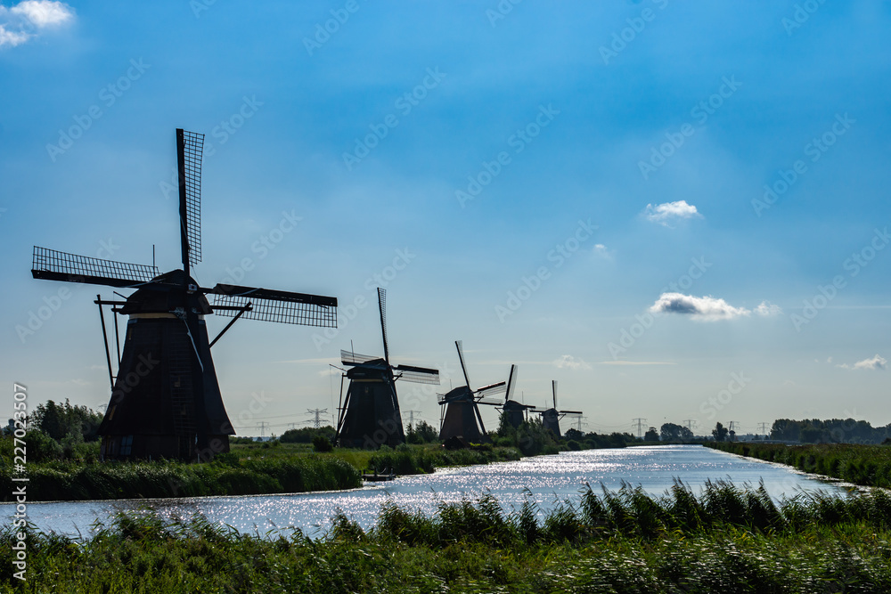 Windmills near the canal with a blue sky