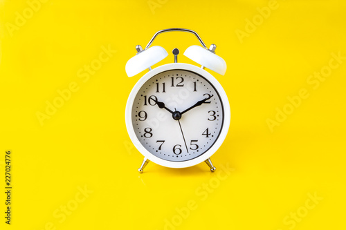 Clock on yellow background with selective focus and crop fragment. Copy space concept