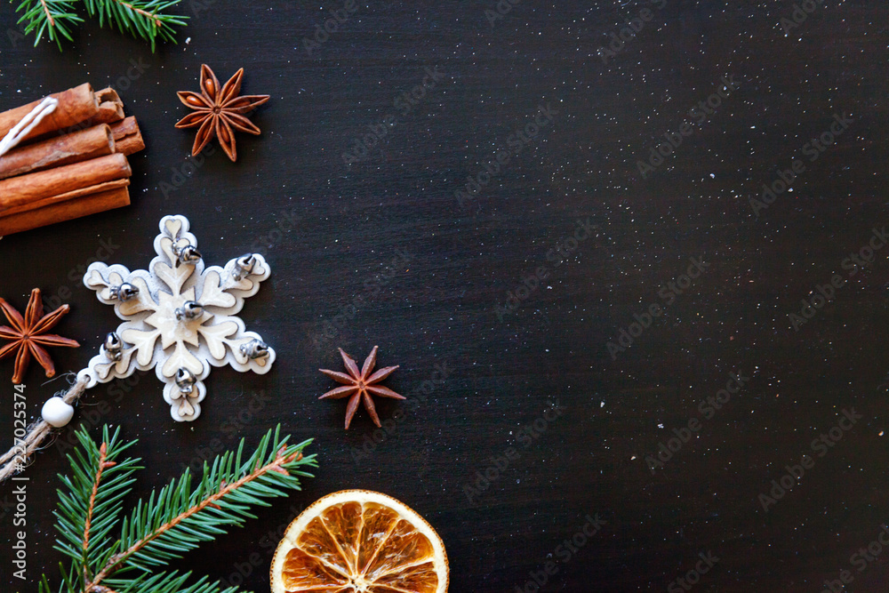 Fototapeta premium Christmas New Year Composition winter objects fir branch, baubles, cinnamon, ball on dark black background. Flat lay, top view, copy space. Christmas december time for celebration concept