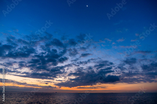夜明けの海、空に月 © Kouzi.Uozumi
