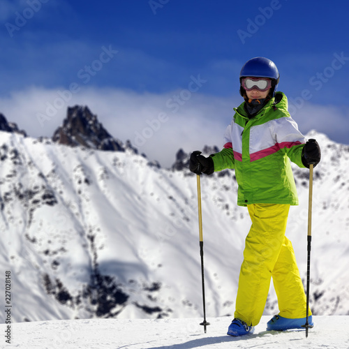 Young skier with ski poles in snowy mountains at sun winter day © BSANI