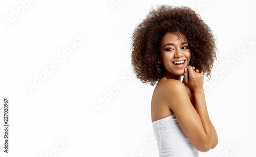 Portrait of smiling african american woman looking on empty space isolated on white background photo