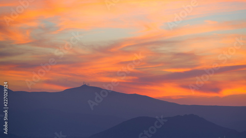 Zachód słońca nad górami z pomarańczowymi chmurami