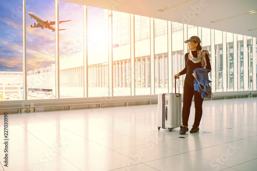 single woman and traveling luggage standing in airport terminal building