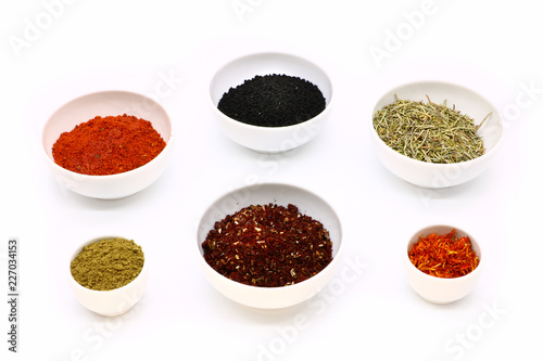 different spices in a white ceramic cup  isolated