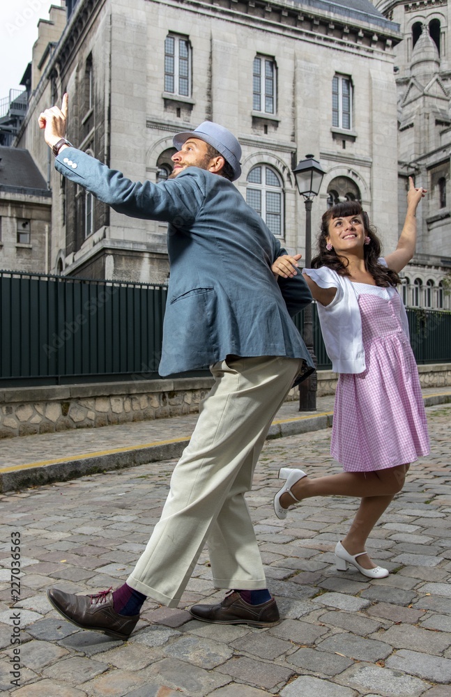 A couple of lovers dressed retro style dancing  in the streets of Montmartre, Paris, France