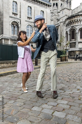 A couple of lovers dressed retro style dancing in the streets of Montmartre, Paris, France