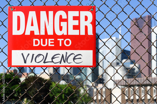  Sign danger due to violence hanging on the fence