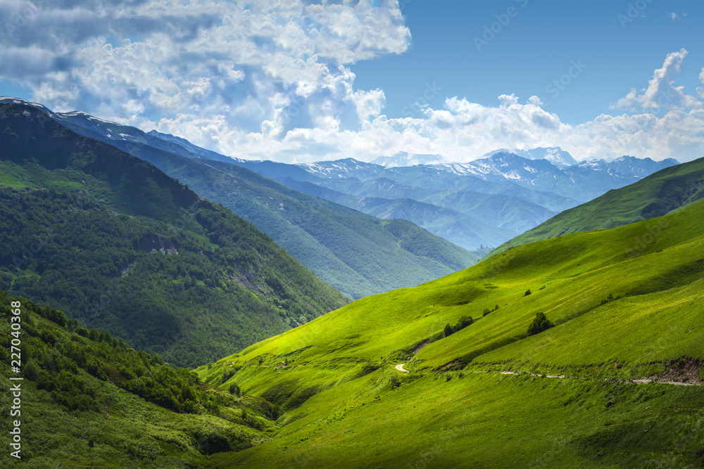 Beautiful view on mountains ranges. Mountain landscape on summer sunny day in Svaneti, Georgia. Alpine valley. Caucasus highlands. Amazing nature. Scenery grassy hills. Wonderful nature.