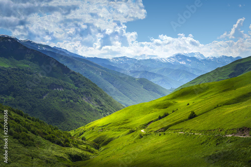 Beautiful view on mountains ranges. Mountain landscape on summer sunny day in Svaneti  Georgia. Alpine valley. Caucasus highlands. Amazing nature. Scenery grassy hills. Wonderful nature.