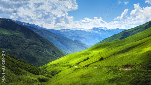 Obraz na płótnie Mountain green alpine valley. Bright Mountains landscape. Hills covered by green grass. Grassy highlands in Svaneti region of Georgia on summer sunny day. Amazing view on Caucasus nature w salonie