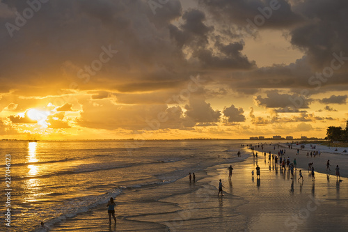 USA, Florida, Fort Myers, silhouettes of Fort Myers Beach and tourists with a huge rain cloud above during sunset photo