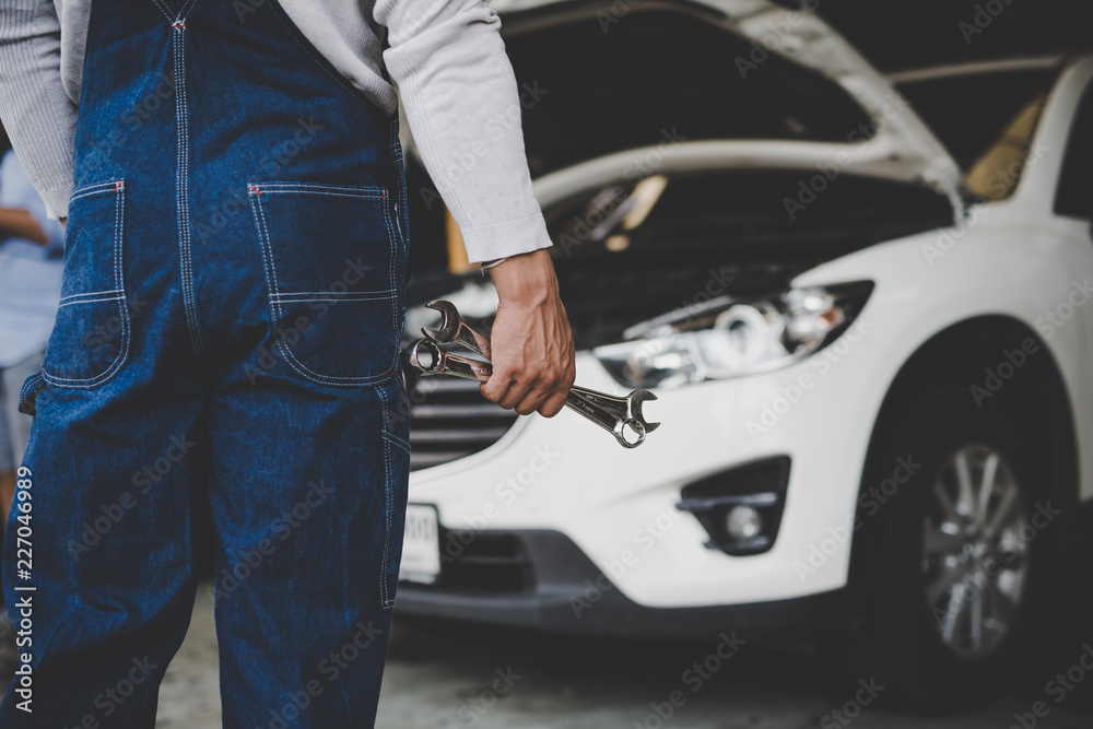 Hand of car mechanic with wrench at service center repair Hand of car mechanic with wrench at service center repair