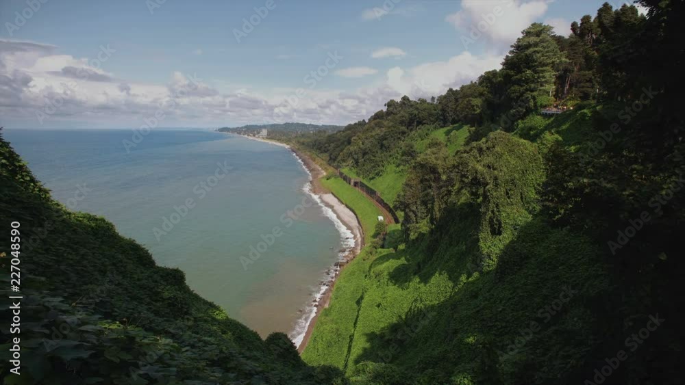 Mountains with tropical trees bushes, cliff to stone beach railway tracks and tunnel botanical garden on hilly locality Mountains with tropical trees bushes, cliff to stone beach railway tracks and tunnel botanical garden on hilly locality