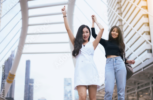 Portrait of couple happy asian female with arms raised,Hands up and success