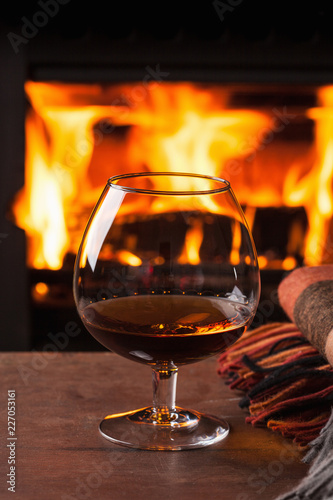 glass of cognac in front of fireplace